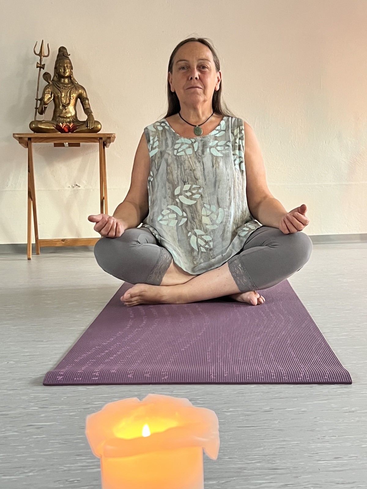 Cornelia en pratique de yoga, assise sur son tapis